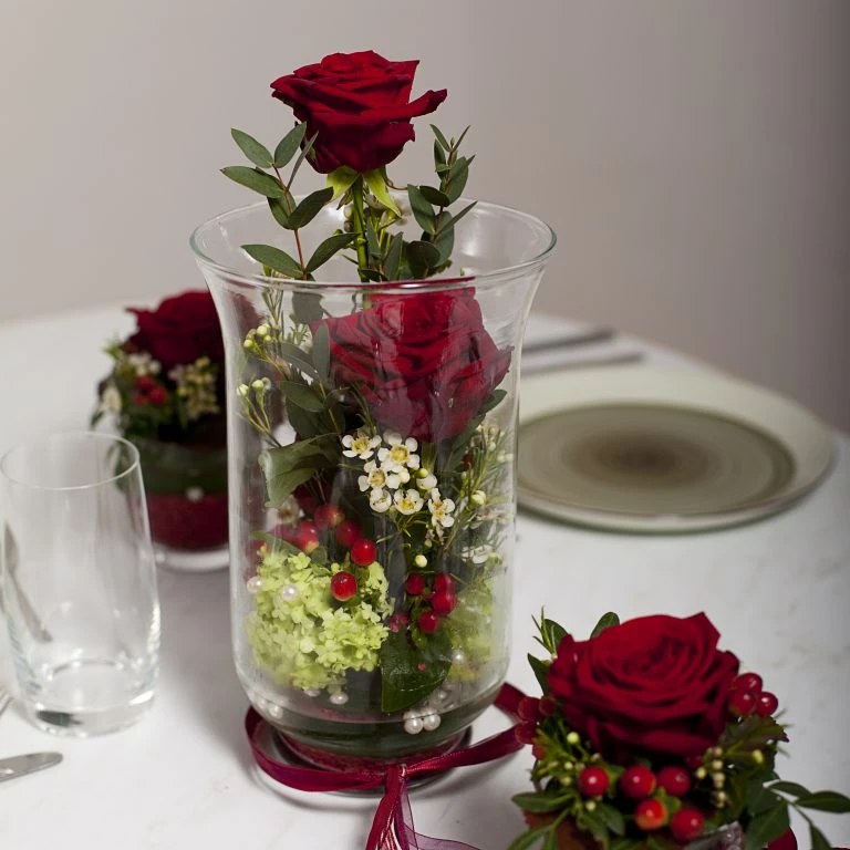 Rote Rosen mit Hortensie und Beeren im hohen Glas
