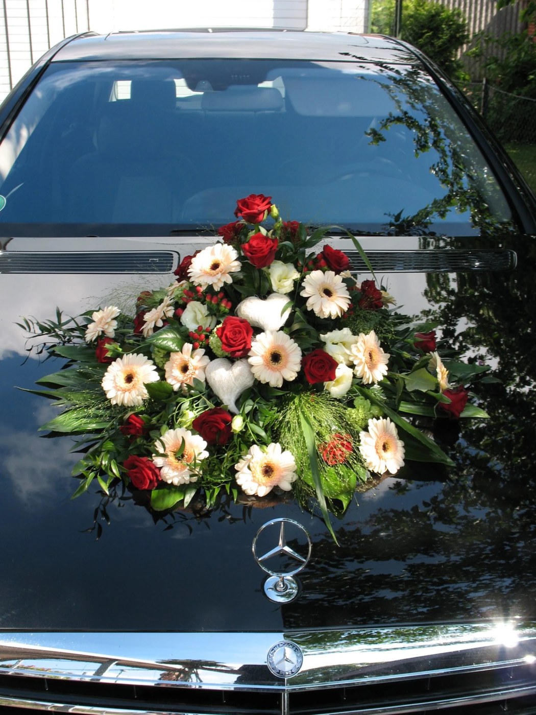 Autoschmuck mit Rosen, Gerbera und Herzen auf der Motorhaube