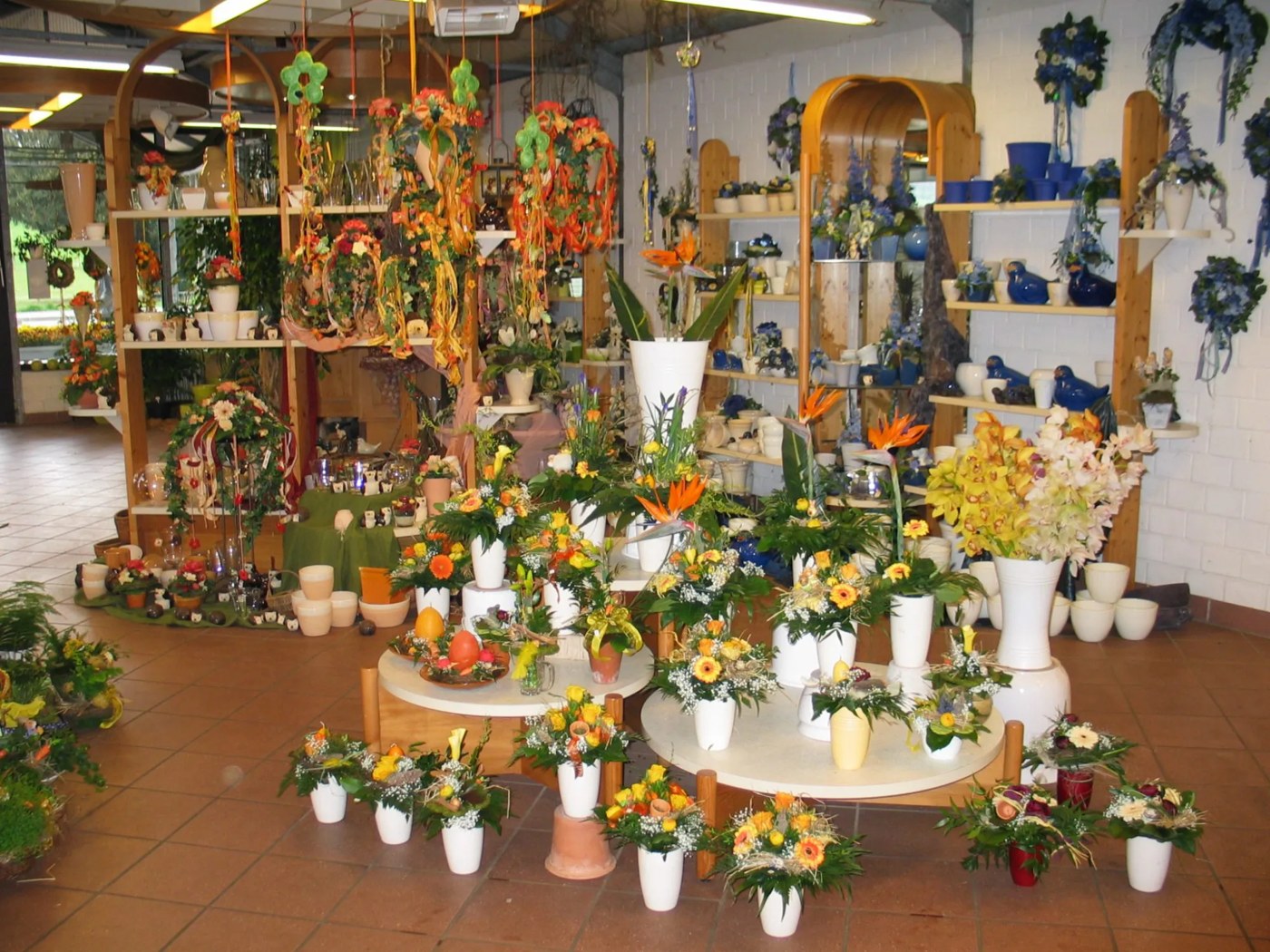 Blumenladen mit gebundenen Sträußen in weißen Vasen, Orchideen und Keramik